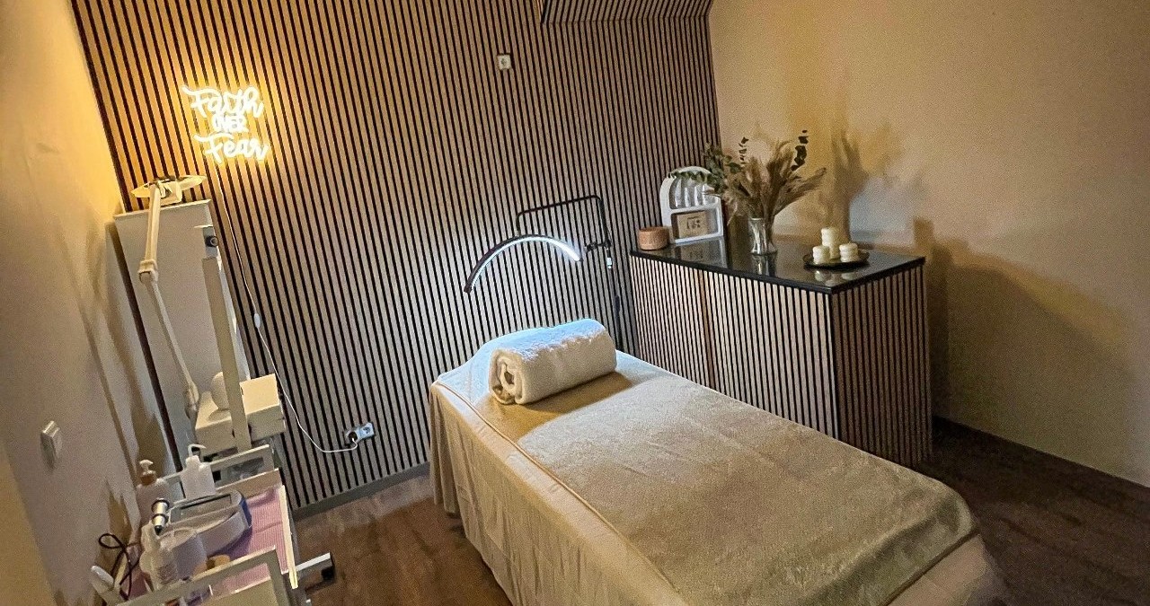 Het behandelbed met een opgerolde handdoek voor de houten lamellenwand